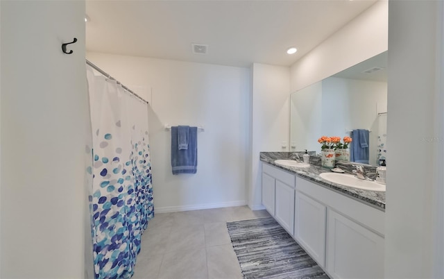 bathroom with tile patterned floors and dual bowl vanity