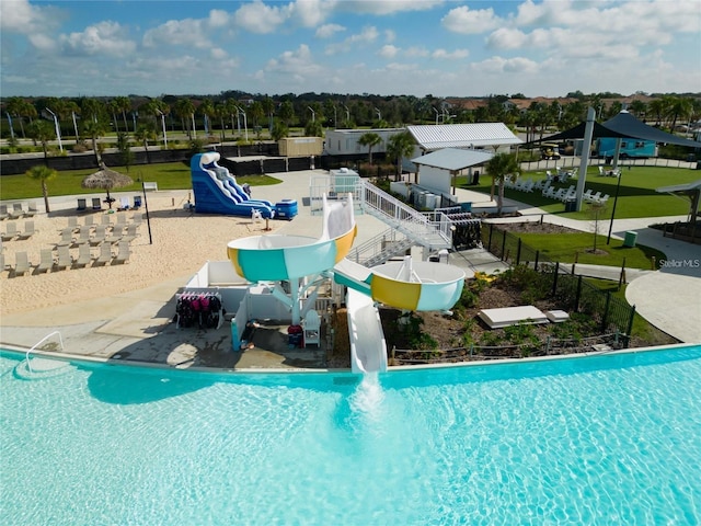 view of swimming pool with a water slide and a patio area