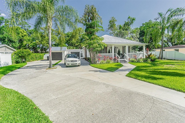 view of front facade featuring a garage, a front yard, an outdoor structure, and a porch