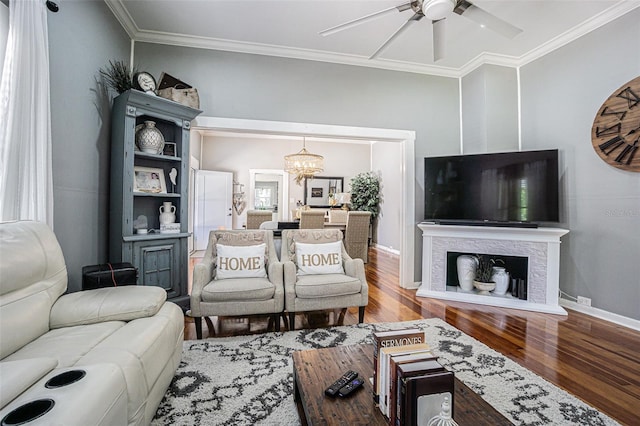 living room with wood-type flooring, ceiling fan with notable chandelier, and crown molding