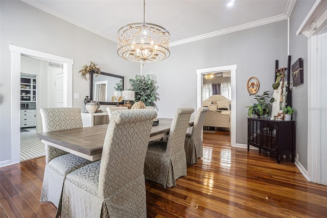 dining room with dark hardwood / wood-style floors, crown molding, and a chandelier