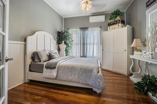 bedroom featuring dark hardwood / wood-style floors, ceiling fan, ornamental molding, and a wall mounted air conditioner