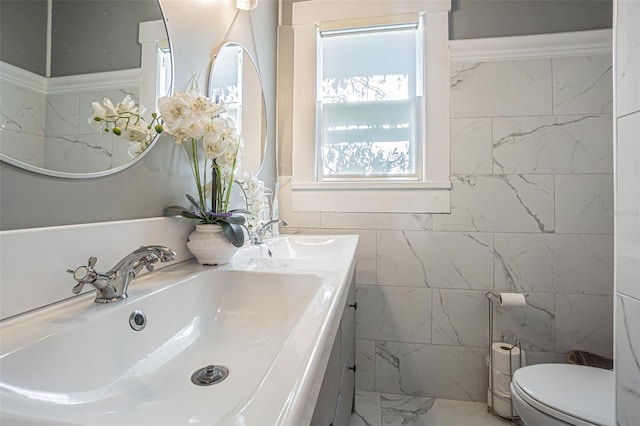 bathroom featuring dual bowl vanity, tile walls, toilet, and tile floors