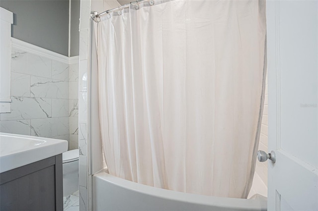 full bathroom featuring tile walls, shower / bath combination with curtain, vanity, and toilet