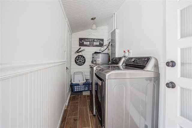 washroom featuring washer hookup, washing machine and clothes dryer, dark hardwood / wood-style floors, wooden walls, and gas water heater