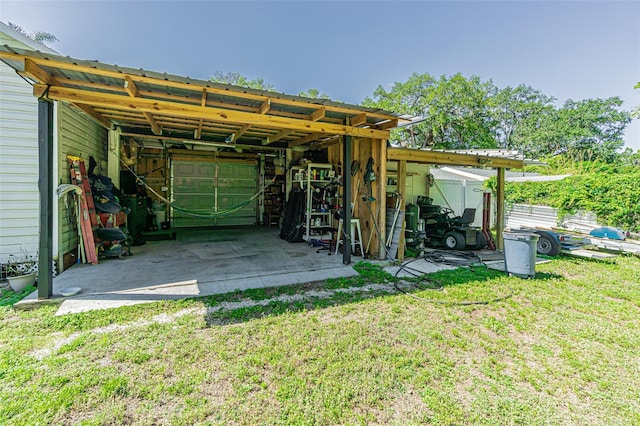 back of house featuring an outdoor structure, a garage, and a yard