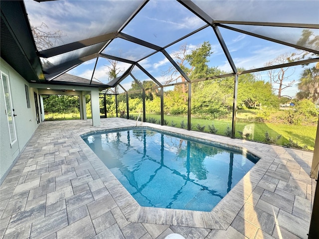 view of pool with a patio area and glass enclosure