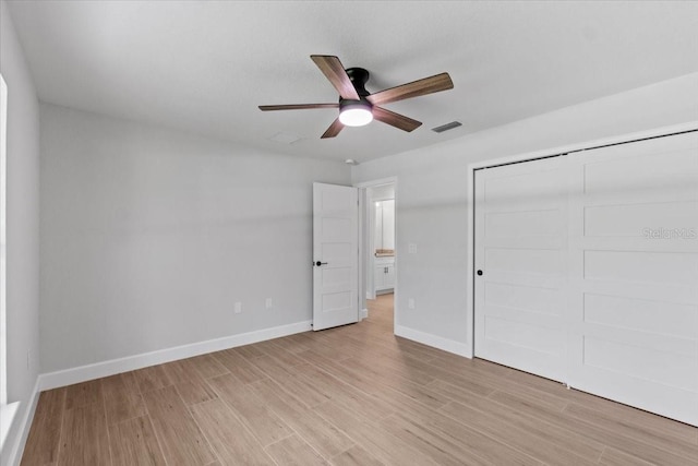 unfurnished bedroom with ceiling fan, a closet, and light hardwood / wood-style flooring