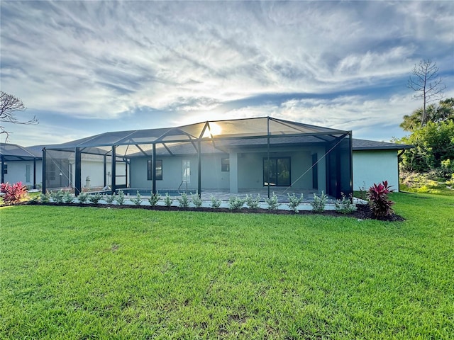 rear view of property featuring glass enclosure and a lawn