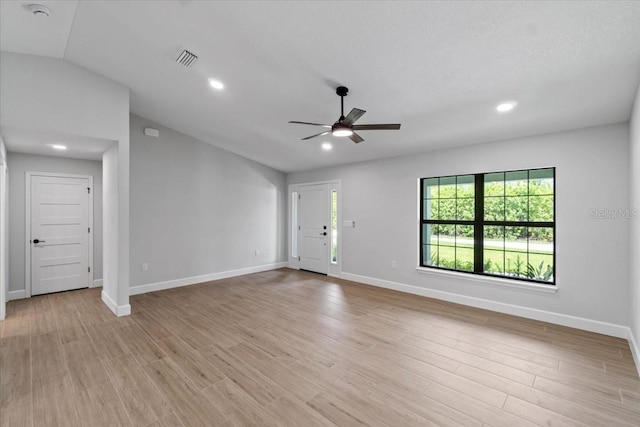 unfurnished living room with ceiling fan, light wood-type flooring, and vaulted ceiling