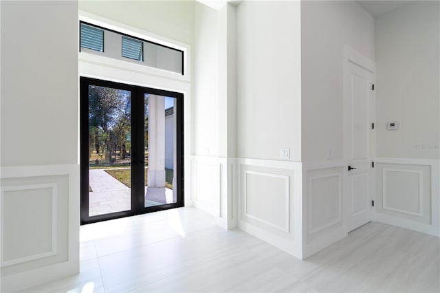 entryway with french doors and light tile patterned flooring