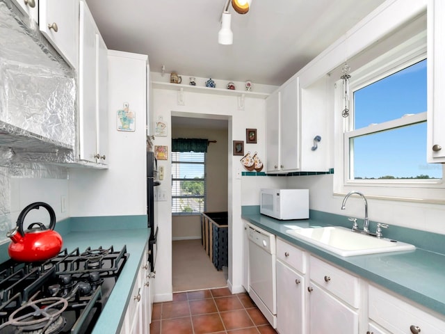 kitchen featuring white cabinets, sink, white appliances, and dark tile flooring