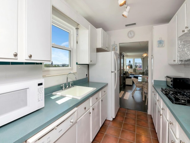 kitchen with a healthy amount of sunlight, sink, white cabinets, and white appliances