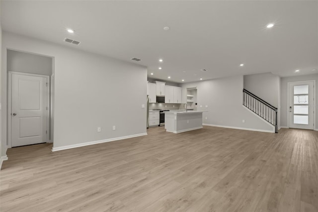 unfurnished living room featuring light hardwood / wood-style floors and sink