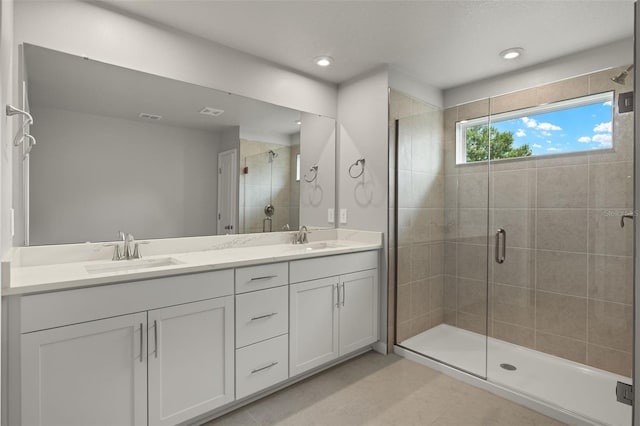 bathroom featuring vanity, a shower with shower door, and tile patterned flooring