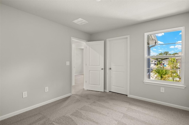 unfurnished bedroom featuring light carpet