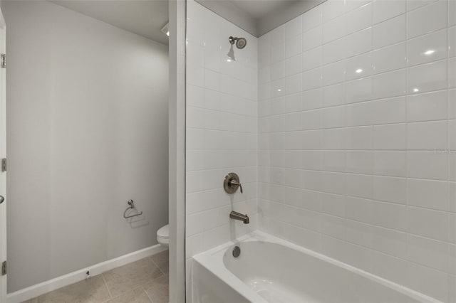 bathroom with tile patterned flooring, toilet, and tiled shower / bath combo