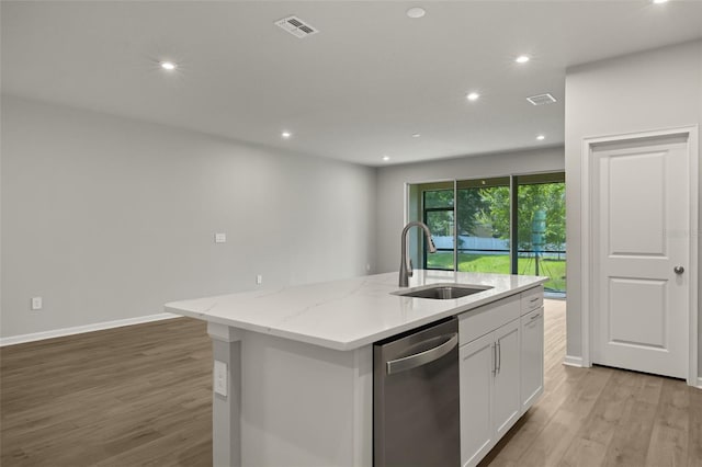 kitchen with light hardwood / wood-style floors, an island with sink, stainless steel dishwasher, sink, and white cabinets