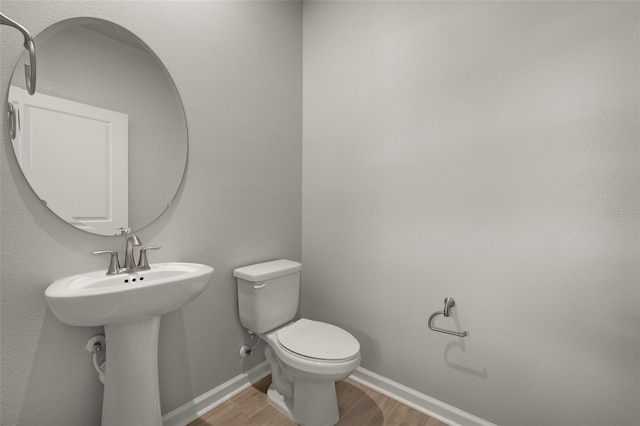 bathroom with toilet and hardwood / wood-style flooring