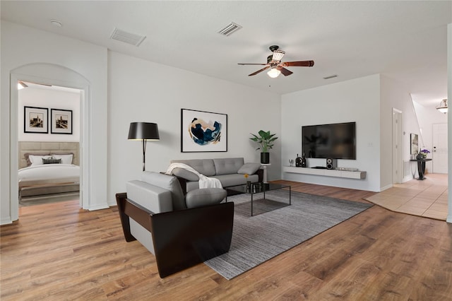 living room with light hardwood / wood-style floors and ceiling fan