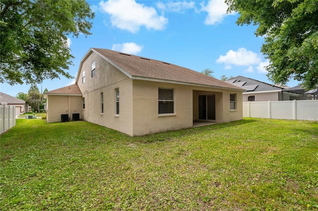 back of house featuring central AC and a lawn