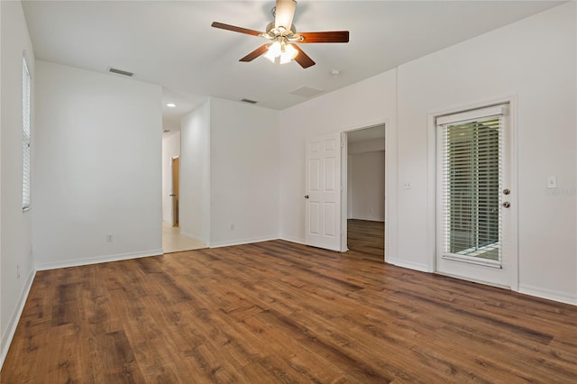 empty room with dark hardwood / wood-style flooring and ceiling fan