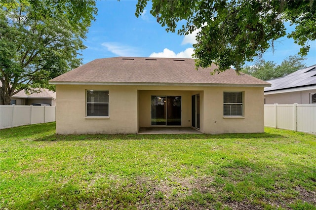 rear view of property with a yard and a patio area