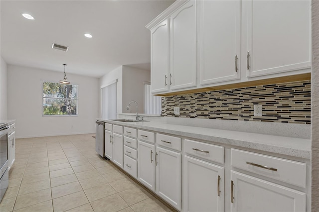 kitchen with sink, decorative light fixtures, appliances with stainless steel finishes, white cabinets, and backsplash