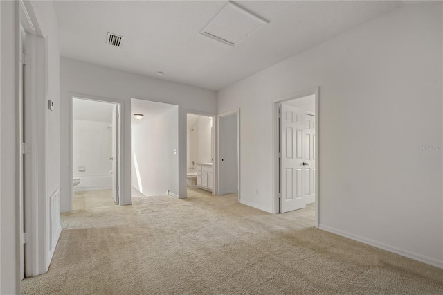 unfurnished bedroom featuring connected bathroom and light colored carpet