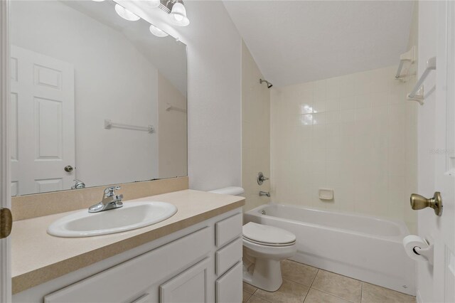 full bathroom featuring tiled shower / bath, tile patterned floors, toilet, and vanity