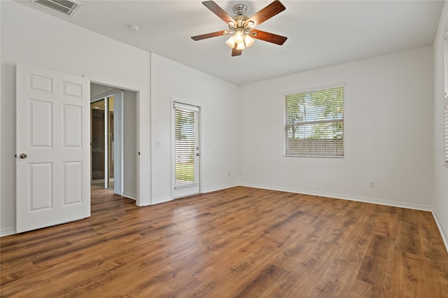 spare room featuring dark wood-type flooring and ceiling fan