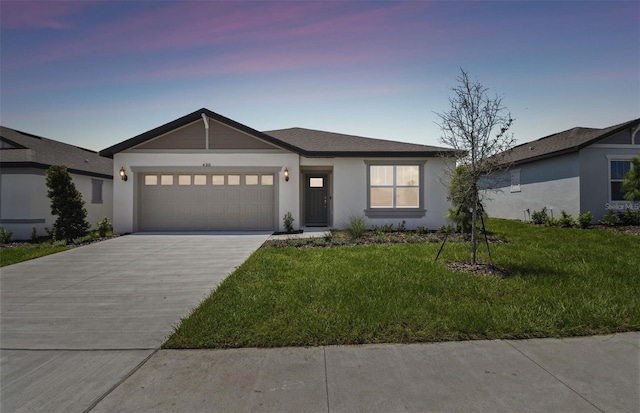 view of front of property featuring a yard and a garage