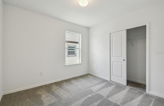 unfurnished bedroom with a closet and carpet floors