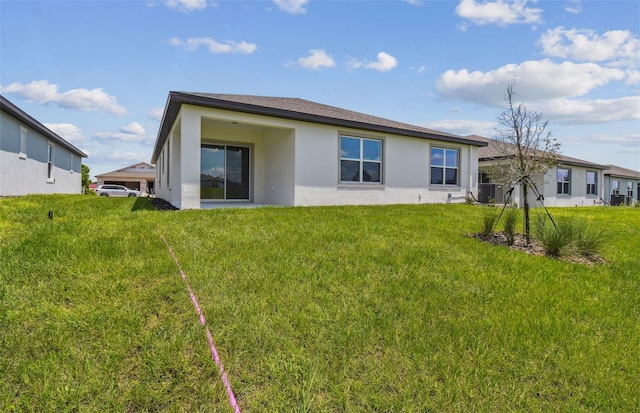 rear view of property featuring central AC unit and a lawn