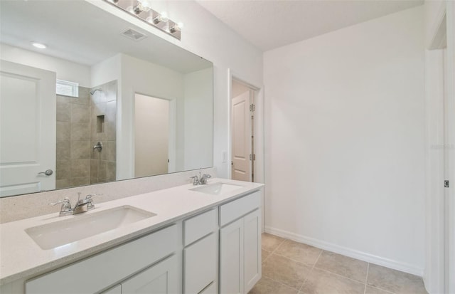 bathroom featuring tile patterned flooring, vanity, and tiled shower