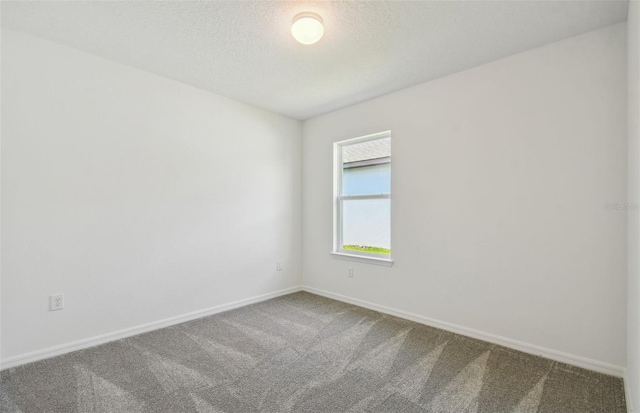 carpeted spare room with a textured ceiling