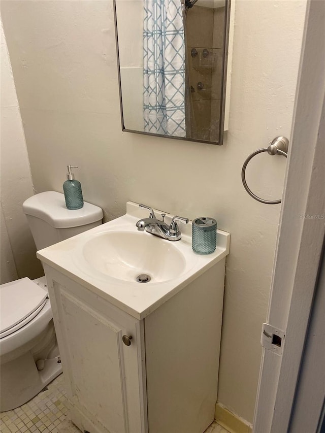 bathroom with tile floors, toilet, and oversized vanity