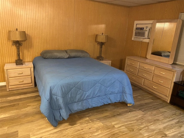 bedroom featuring light hardwood / wood-style flooring and wood walls