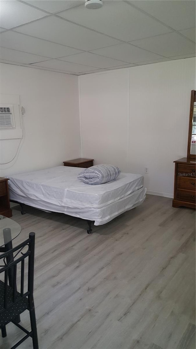 bedroom with hardwood / wood-style flooring and a wall mounted air conditioner