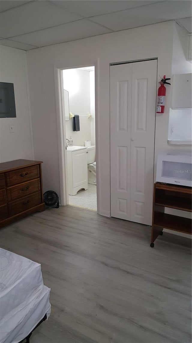 bedroom featuring wood-type flooring, ensuite bath, washing machine and dryer, and a closet