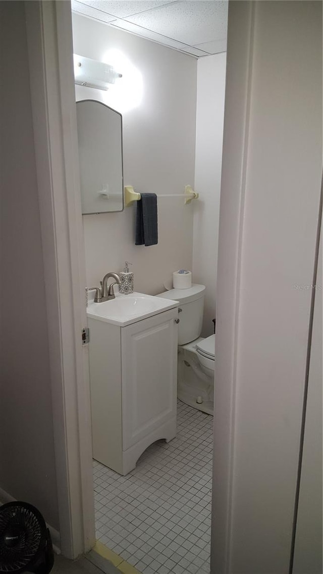 bathroom featuring toilet, tile floors, and vanity