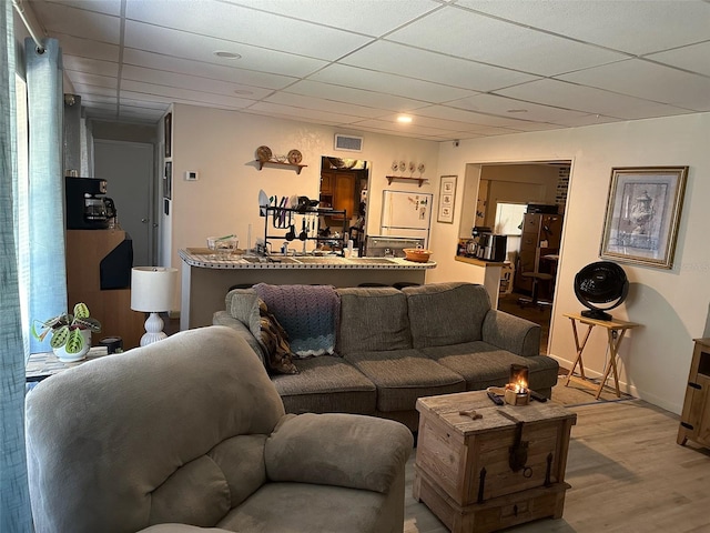 living room featuring a drop ceiling and hardwood / wood-style flooring