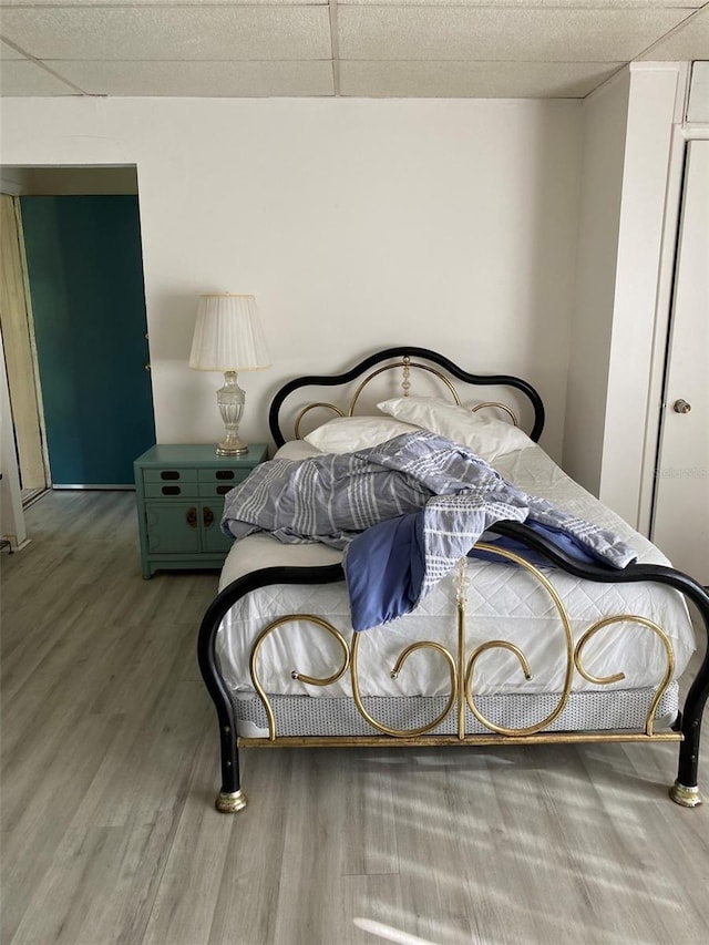 bedroom with wood-type flooring and a paneled ceiling