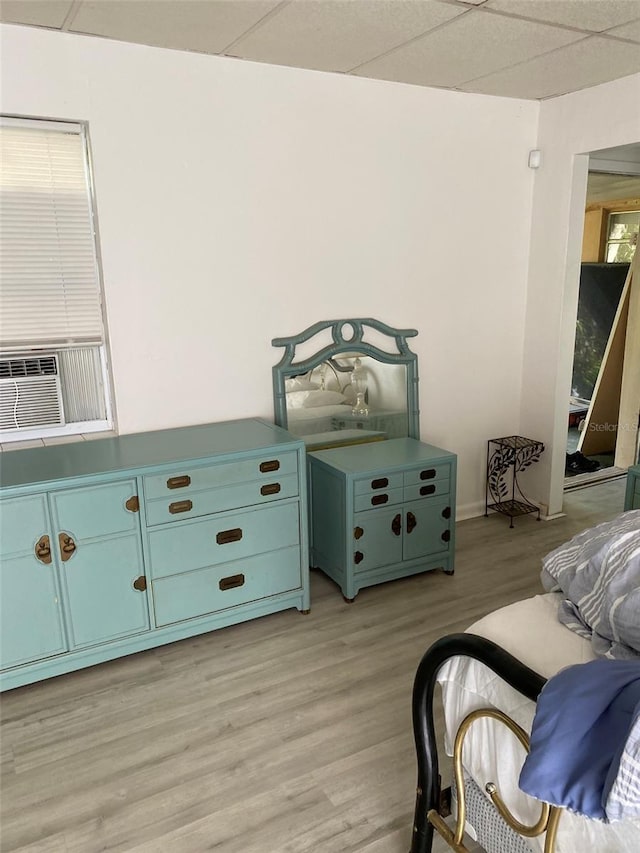 bedroom featuring a paneled ceiling and light hardwood / wood-style flooring