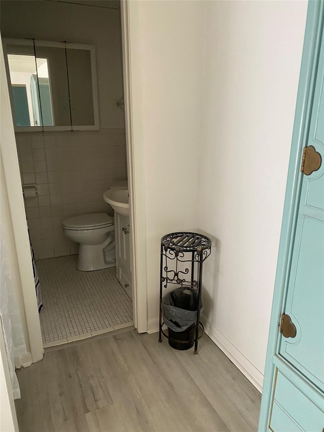 bathroom featuring tile walls, wood-type flooring, vanity, and toilet