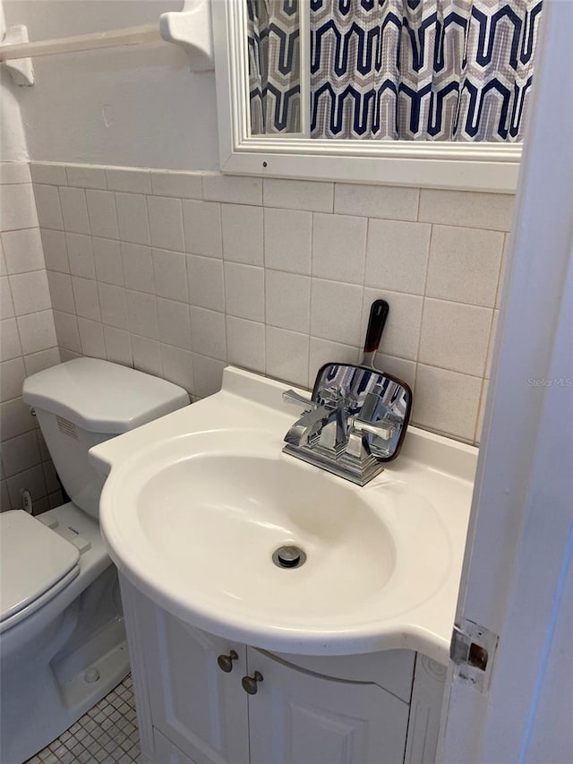 bathroom with tile walls, vanity, tile floors, and toilet