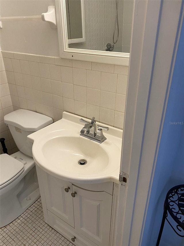 bathroom with tile walls, backsplash, toilet, tile flooring, and vanity