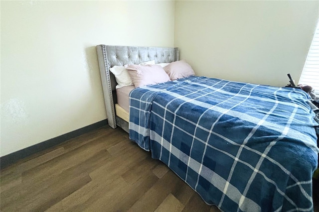 bedroom with dark hardwood / wood-style flooring