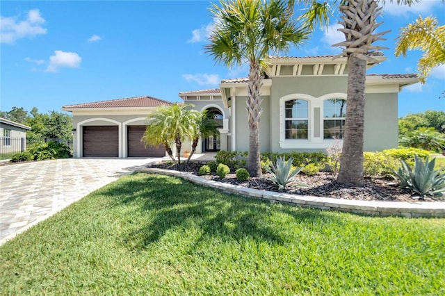 mediterranean / spanish house featuring a garage and a front lawn