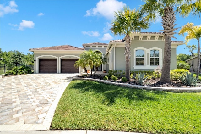 mediterranean / spanish-style home featuring a front yard and a garage